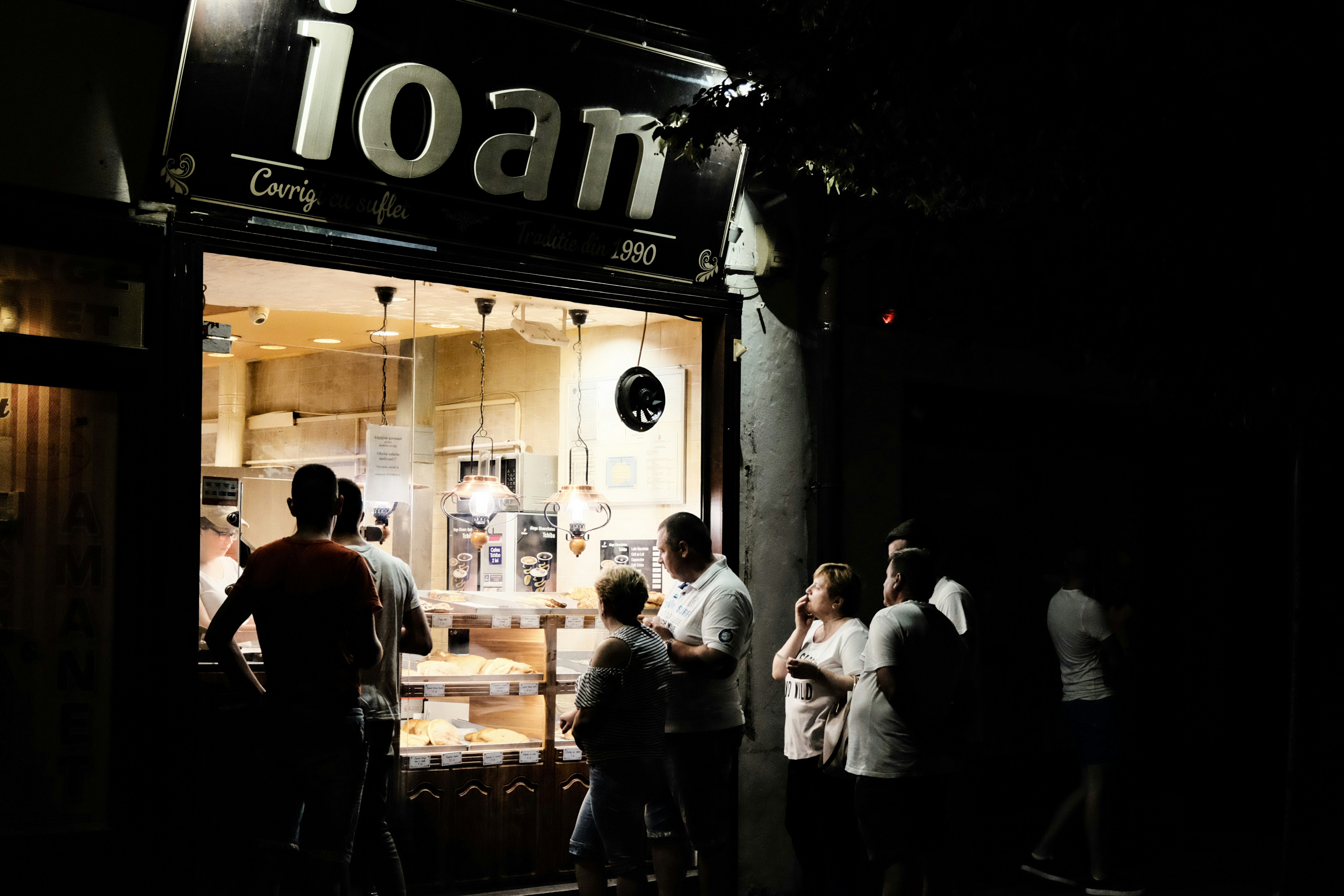 people standing outside the shop during nighttime